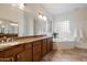 Bathroom with double sinks, granite countertops, and a soaking tub at 8817 S 18Th Way, Phoenix, AZ 85042