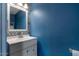 Half bath featuring a modern vanity and stylish wallpaper at 9509 W Tonopah Dr, Peoria, AZ 85382