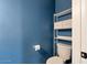 Bright half bathroom with blue walls, open shelving and a modern toilet at 9509 W Tonopah Dr, Peoria, AZ 85382