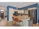 Bright kitchen with an island, stainless steel appliances, wood floors and pendant lighting at 9509 W Tonopah Dr, Peoria, AZ 85382