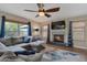 Inviting living room with sectional couch, ceiling fan, and fireplace with blue tile at 9509 W Tonopah Dr, Peoria, AZ 85382