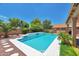Charming backyard pool with decorative stone accents, complimented by mature trees and landscaping at 9509 W Tonopah Dr, Peoria, AZ 85382