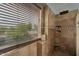 Tiled shower with decorative trim, built in shelves, and a window at 9509 W Tonopah Dr, Peoria, AZ 85382