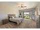 Serene main bedroom with a ceiling fan, access to the backyard, and neutral decor at 9722 W Prospector Dr, Queen Creek, AZ 85144