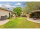Lush backyard featuring a covered patio, citrus tree, and a well-manicured lawn at 9834 E Fairview Ave, Mesa, AZ 85208