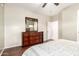 A large dresser with mirror provides storage in this bedroom with wood floors at 9834 E Fairview Ave, Mesa, AZ 85208