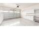 Spacious garage with epoxy floors, white storage cabinets, and an automatic garage door at 9834 E Fairview Ave, Mesa, AZ 85208