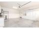 Clean garage featuring epoxy floors, overhead lighting, and white storage cabinets and shelves at 9834 E Fairview Ave, Mesa, AZ 85208