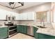 Stylish kitchen with stainless steel appliances and green base cabinets, granite countertops at 9834 E Fairview Ave, Mesa, AZ 85208