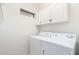 Bright laundry room with overhead cabinets and a side-by-side washer and dryer at 9834 E Fairview Ave, Mesa, AZ 85208