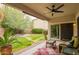 Covered patio with comfortable seating overlooks a well-maintained yard with mature landscaping at 9834 E Fairview Ave, Mesa, AZ 85208