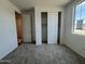 Sunlit bedroom featuring plush carpet, neutral walls, large window, and a sizable closet with sliding doors at 15790 W Cheryl Dr, Waddell, AZ 85355