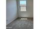 Clean bedroom features neutral carpet, bright natural light, and a nearby electrical outlet for convenience at 15790 W Cheryl Dr, Waddell, AZ 85355