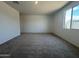 Bedroom with a large window and neutral carpet, ready for personalization at 15790 W Cheryl Dr, Waddell, AZ 85355