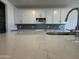 This kitchen features white cabinets, blue subway tile, and a sink with marble countertops at 15790 W Cheryl Dr, Waddell, AZ 85355