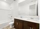 Bathroom featuring a double sink, dark cabinets, and a shower over bath at 17410 W Eva St, Waddell, AZ 85355
