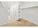 Well-organized walk-in closet with open shelving and a clear view of the adjacent bathroom, maximizing space and convenience at 17410 W Eva St, Waddell, AZ 85355