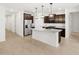 Modern kitchen with an island bar, granite countertops, stainless steel appliances, and dark wood cabinets at 17410 W Eva St, Waddell, AZ 85355