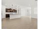 Open-plan living room and kitchen with light wood-style tile flooring and modern lighting at 17410 W Eva St, Waddell, AZ 85355