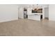 Open-plan living room with light wood-style tile flooring leading into the kitchen at 17410 W Eva St, Waddell, AZ 85355