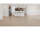 Open-plan living room and kitchen with light wood-style tile flooring and modern lighting at 17410 W Eva St, Waddell, AZ 85355
