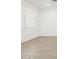 Bright, empty living room featuring large windows and neutral walls with white trim at 17410 W Eva St, Waddell, AZ 85355