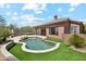 A backyard features a pool with rock accents, putting green, and a covered patio perfect for outdoor living at 11451 E Christmas Cholla Dr, Scottsdale, AZ 85255