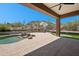 Relaxing backyard featuring a pool, putting green, desert landscaping, and mountain views at 11451 E Christmas Cholla Dr, Scottsdale, AZ 85255