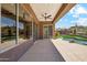 View of a covered patio with ceiling fan and desert views of the pool and mountains from the windows at 11451 E Christmas Cholla Dr, Scottsdale, AZ 85255