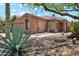 Charming home exterior with desert landscaping, mature trees, and a quaint courtyard entrance at 11451 E Christmas Cholla Dr, Scottsdale, AZ 85255