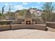 An outdoor fireplace with seating and desert views offers a cozy spot for relaxation and entertainment at 11451 E Christmas Cholla Dr, Scottsdale, AZ 85255