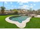 Inviting backyard pool with lush landscaping and outdoor fireplace, perfect for relaxation and entertaining at 11451 E Christmas Cholla Dr, Scottsdale, AZ 85255