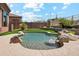Custom pool with rock waterfall feature in a beautifully landscaped backyard at 11451 E Christmas Cholla Dr, Scottsdale, AZ 85255