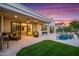Beautiful backyard with a sparkling pool, lush artificial turf, and comfortable seating areas for entertaining at 11977 N 81St St, Scottsdale, AZ 85260