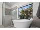 The primary bathroom offers a standalone tub and separate shower with backyard views at 11977 N 81St St, Scottsdale, AZ 85260