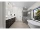 Bright primary bathroom boasts dual sinks, a soaking tub and luxurious walk-in shower at 11977 N 81St St, Scottsdale, AZ 85260