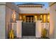 Home's grand entrance features a custom metal gate, desert landscaping, and modern lighting fixtures at 11977 N 81St St, Scottsdale, AZ 85260