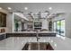 A contemporary kitchen boasts an island with bar seating and stainless steel appliances with a view to the pool at 11977 N 81St St, Scottsdale, AZ 85260