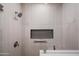 Modern shower featuring stylish tilework, sleek fixtures, glass door, and a convenient built-in niche at 11977 N 81St St, Scottsdale, AZ 85260