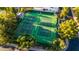 Aerial view of well-maintained tennis courts surrounded by lush landscaping and a covered seating area at 11977 N 81St St, Scottsdale, AZ 85260