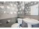 Toilet and sink with unique silver floral wallpaper in this modern bathroom at 13083 N 87Th Dr, Peoria, AZ 85381