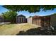 Backyard with grass, storage shed and partial views of the neighboring houses at 15825 W Acapulco Ln, Surprise, AZ 85379
