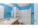 Well-lit bathroom with blue walls, a white vanity, and a shower-tub combination at 15825 W Acapulco Ln, Surprise, AZ 85379