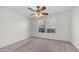 Cozy bedroom with soft carpet, ceiling fan, and bright windows with views of greenery at 15825 W Acapulco Ln, Surprise, AZ 85379