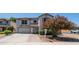 Two-story house with a well-maintained lawn and a blooming tree in the yard at 15825 W Acapulco Ln, Surprise, AZ 85379