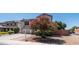 Charming two-story house with desert landscaping and a blooming tree at 15825 W Acapulco Ln, Surprise, AZ 85379