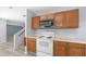 Kitchen featuring matching wooden cabinets and modern microwave and electric range at 15825 W Acapulco Ln, Surprise, AZ 85379