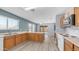 Well-lit kitchen features wood cabinets, an island, and flows to the dining area with sliding glass doors to the backyard at 15825 W Acapulco Ln, Surprise, AZ 85379