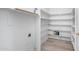 Walk-in pantry with white shelving provides ample storage space and has a wooden style floor at 15825 W Acapulco Ln, Surprise, AZ 85379