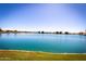 Scenic view of the community lake with blue water and lush green landscaping at 1633 E Lakeside Dr # 25, Gilbert, AZ 85234